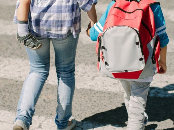 Mutter läuft mit Kind über die Straße
