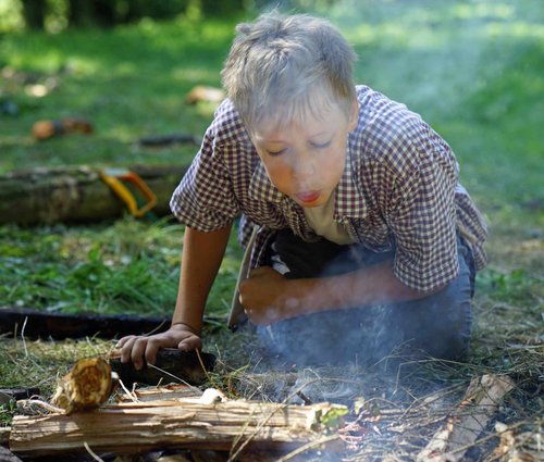 Bei der Ferienaktion "Leben in der Steinzeit" rund um die Luisenhütte in Balve-Wocklum lernen die Kinder unter Aufsicht auch wie sie mit einem Feuerstein ein Feuer entfachen können. Foto: Stephan Sensen/Märkischer Kreis