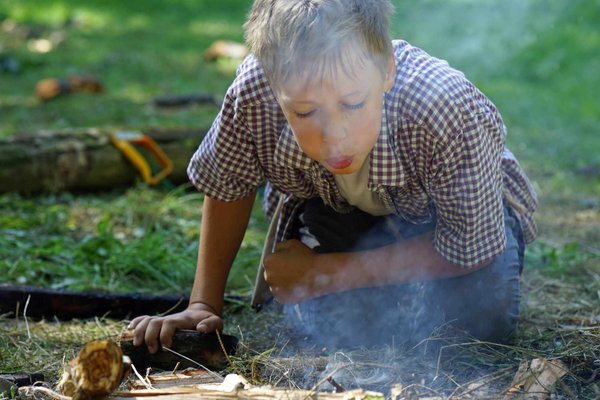 Bei der Ferienaktion "Leben in der Steinzeit" rund um die Luisenhütte in Balve-Wocklum lernen die Kinder unter Aufsicht auch wie sie mit einem Feuerstein ein Feuer entfachen können. Foto: Stephan Sensen/Märkischer Kreis