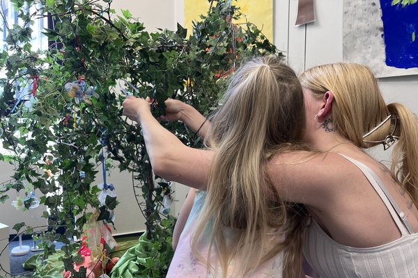 Die Eltern unterstützen ihre Kinder beim Aufhängen der Nuckis am Schnullerbaum. Foto: Katharina Buschmann / Märkischer Kreis