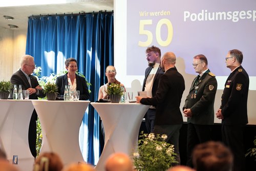 Podiumsgespräch im Kulturhaus Lüdenscheid (von links): Günther Nülle vom Kreissportbund, Unternehmerin Jana Lewe aus Iserlohn, Marie Woeste vom Lüdenscheider Biohof, Lukas Koch vom Festspielverein Balver Höhle, Moderator Marcel Dilling, Stefan Tremmel vom Sauerländer Schützenbund und Kreisbrandmeister Michael Kling. Foto: Sebastian Sendlak / Märkischer Kreis