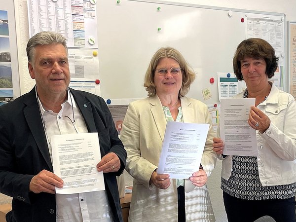 von links: Bernd Falz, Vorsitzender der Freunde der Burg Altena e.V., Museumspädagogin Bernadette Lange und Schulleiterin Gudrun Reinecke-Bartelt präsentieren den Kooperationsvertrag zur Bildungspartnerschaft zwischen der Lenneschule, den „Freunden der Burg Altena“ und den Museen des Märkischen Kreises. Foto: Lenneschule