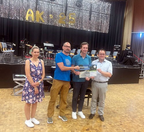 Mitarbeiter des Unternehmens Alutronic Kühlkörper GmbH und Co. KG aus Halver nehmen den Gutschein für das "Networking-Dinner" mit der GWS entgegen. Foto: Stadt Meinerzhagen