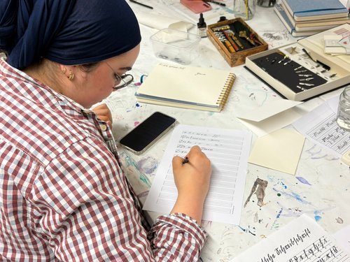 Auch Einblicke in die Kunst der Kalligraphie gab es für die Schülerinnen der Adolf-Reichwein-Gesamtschule aus Lüdenscheid. Foto: Märkischer Kreis