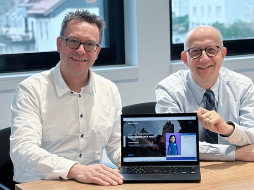 Landrat Ralf Schwarzkopf (rechts) und Andreas Lüsebrink, Fachdienstleiter Digitalisierung und IT (links), stellen gemeinsam den neuen digitalen Avatar auf der Homepage des Märkischen Kreises vor. Foto: Katharina Buschmann / Märkischer Kreis