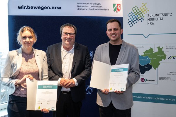 NRW-Verkehrsminister Oliver Krischer (mitte) überreichte Vera Mölders und Raphael Jolly vom Märkischen Kreis die Urkunden zur erfolgreichen Qualifizierung zur Mobilitätsmanagerin bzw. Mobilitätsmanager. Foto: MUNV NRW/Caroline Seidel